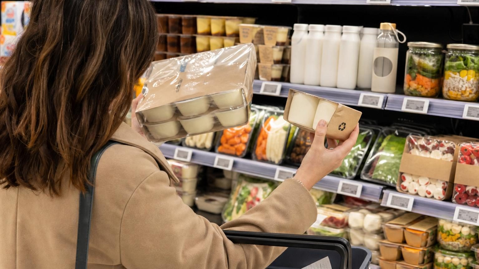 Rayons de supermarché avec des produits aux emballages variés, mettant en avant les informations de tri et les étiquettes de prix au kilo visibles.