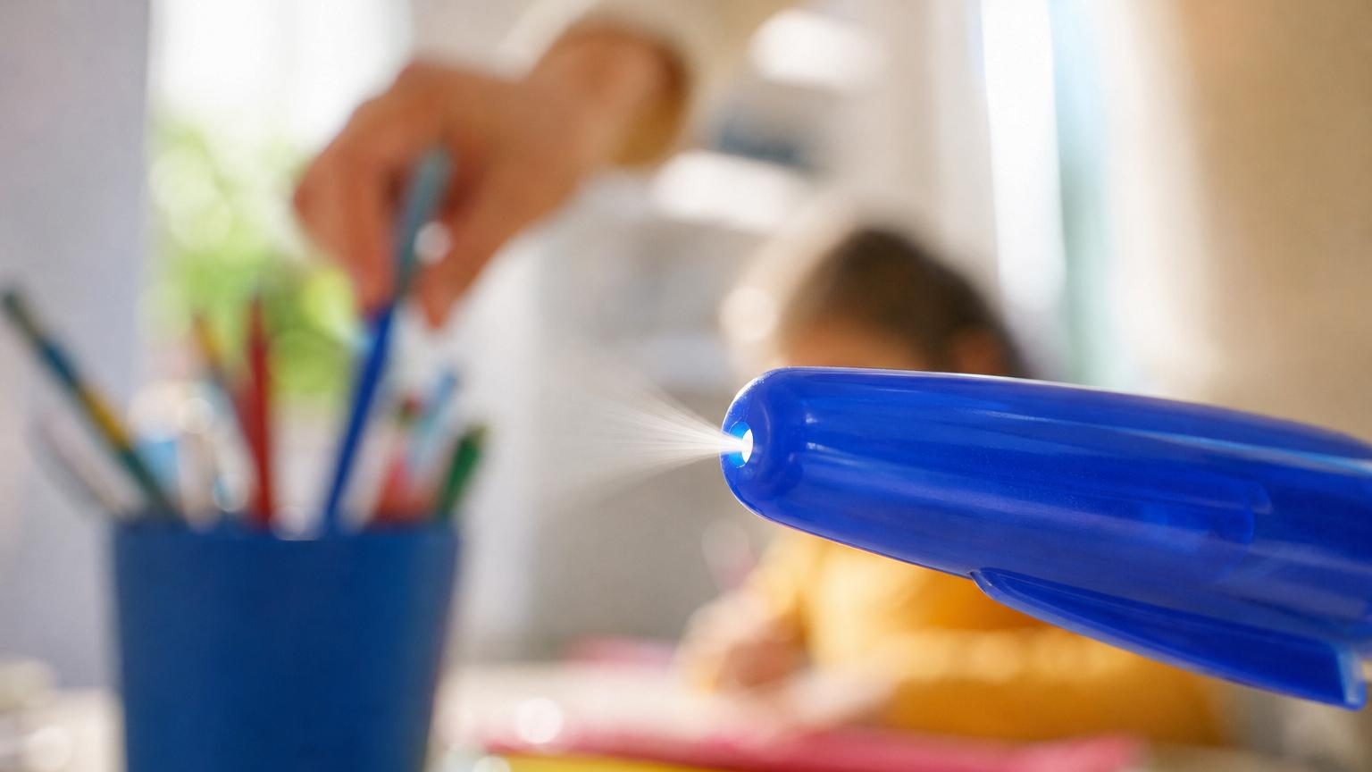 Gros plan sur le capuchon transparent d'un stylo à bille, mettant en évidence le minuscule trou perforé à son extrémité supérieure.