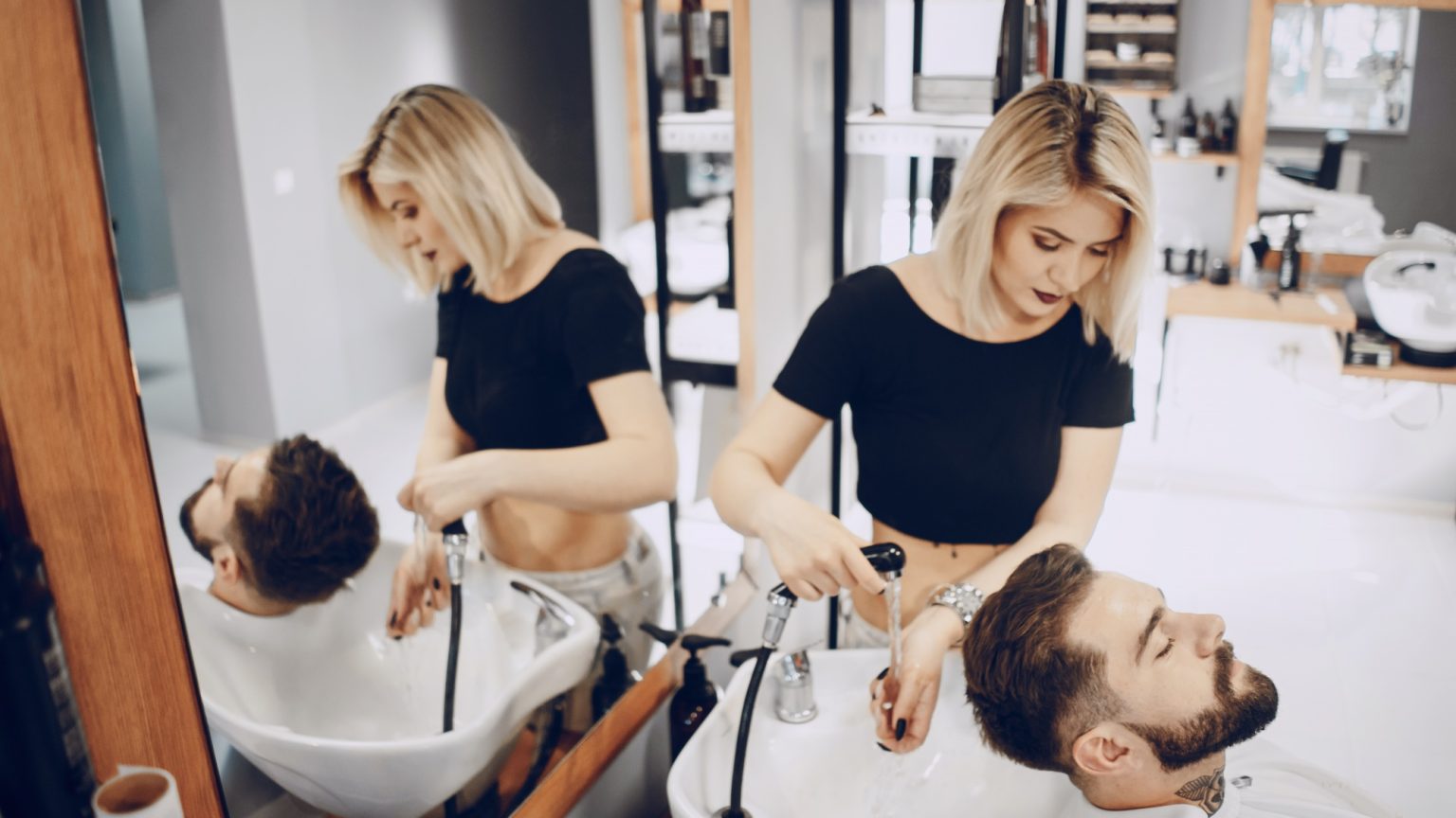 Femme aux cheveux gris et blancs brillants, touchant ses cheveux souples et sains après un soin capillaire.